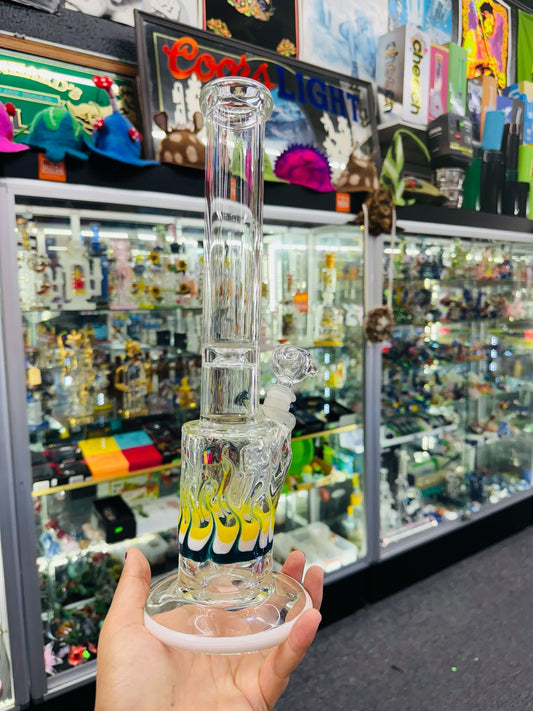 Clear glass smoking device held in front of a store display with various items.